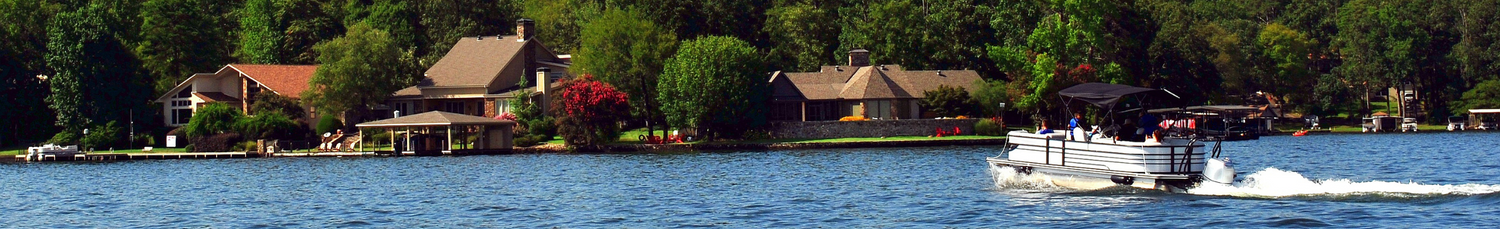 Pontoon boat on a lake with lake side houses in the background